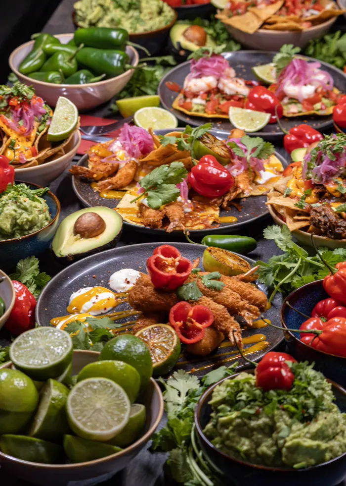 Bord fylt med tostadas, reker, guacamole og nachos hos La Taqueria
